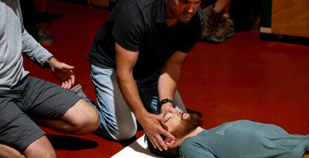 First aid at work course delegate practising CPR on a training manikin