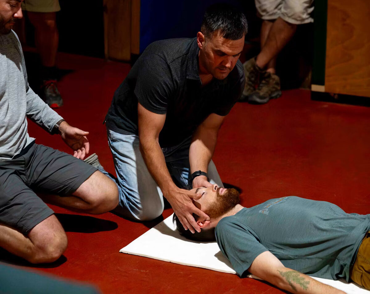 First aid at work course delegate practising CPR on a training manikin